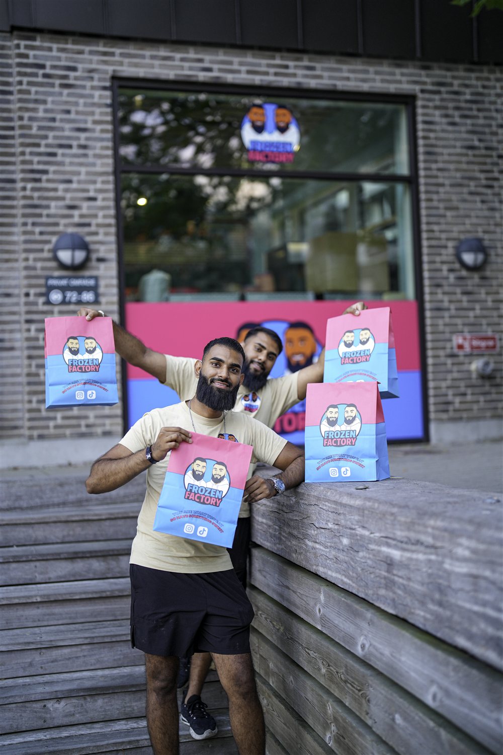 The Frozen Factory founders holding branded takeaway bags outside the shop